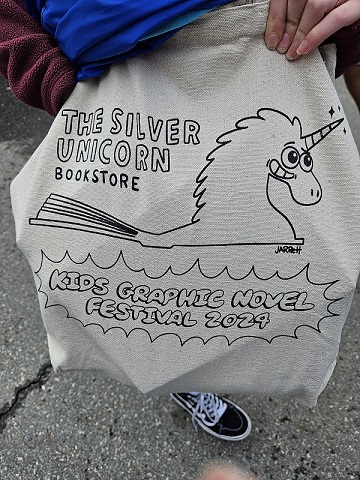 A canvas tote bag that says The Silver Unicorn Bookstore Kids Graphic Novel Festival 2024.