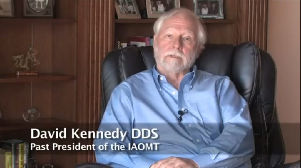 A white-haired and white bearded man sits in a black office chair. The image is labeled "David Kennedy DDS, Past President of IAOMT."