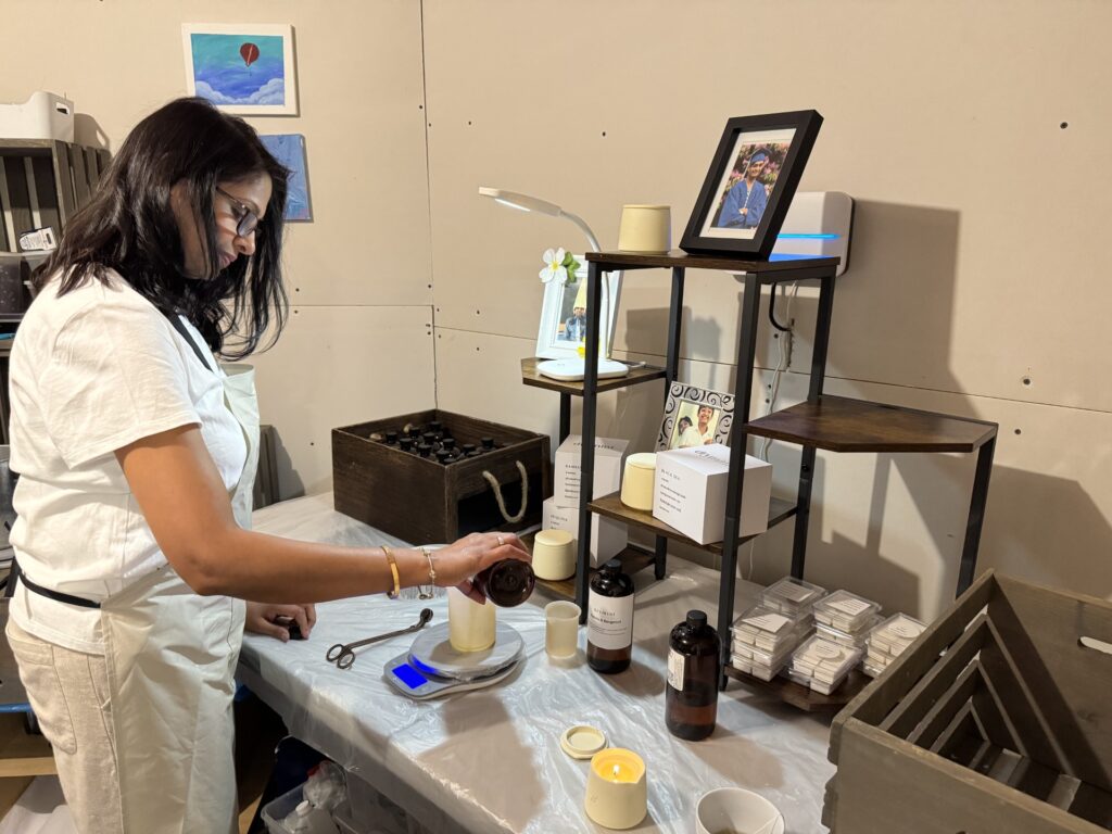 A table turned chemistry lab. A woman pours something from a bottle into a glass container.