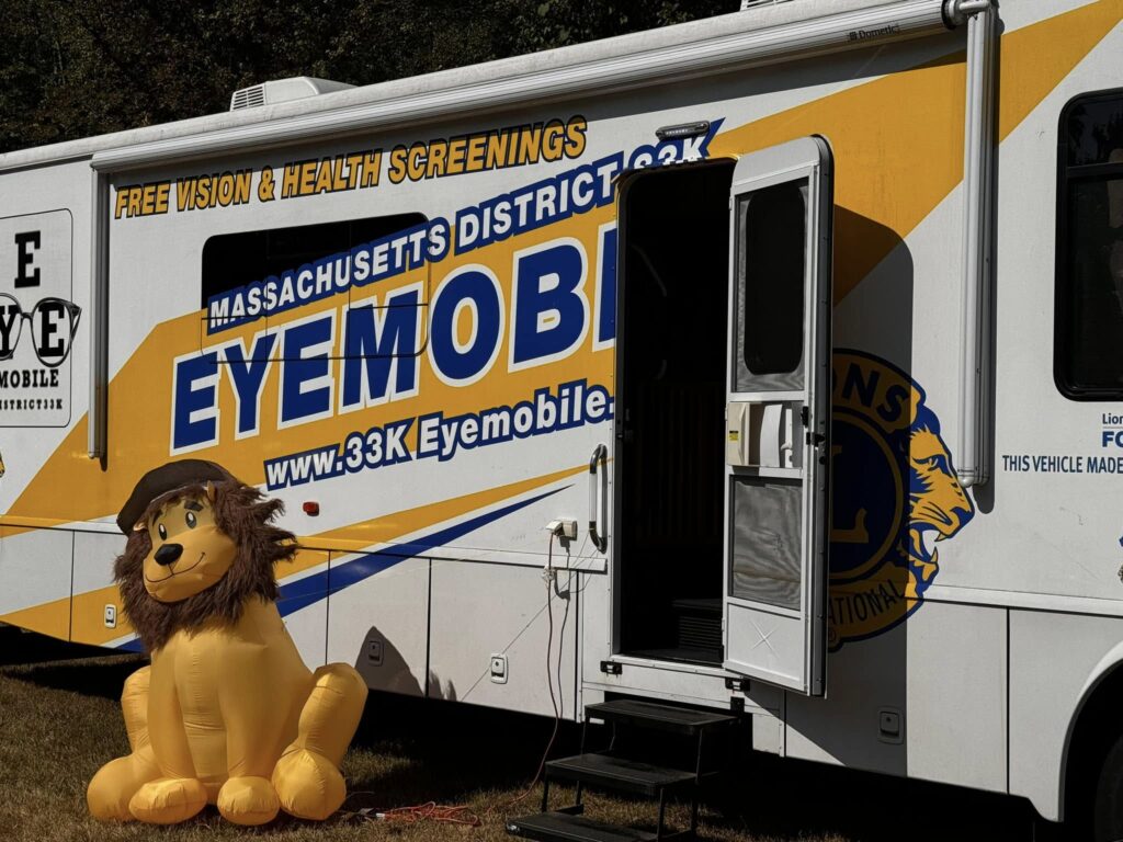 The Massachusetts Lions Club Eyemobile that offers free vision and health screenings. The door is open and there's a friendly blow-up lion waiting for customers.