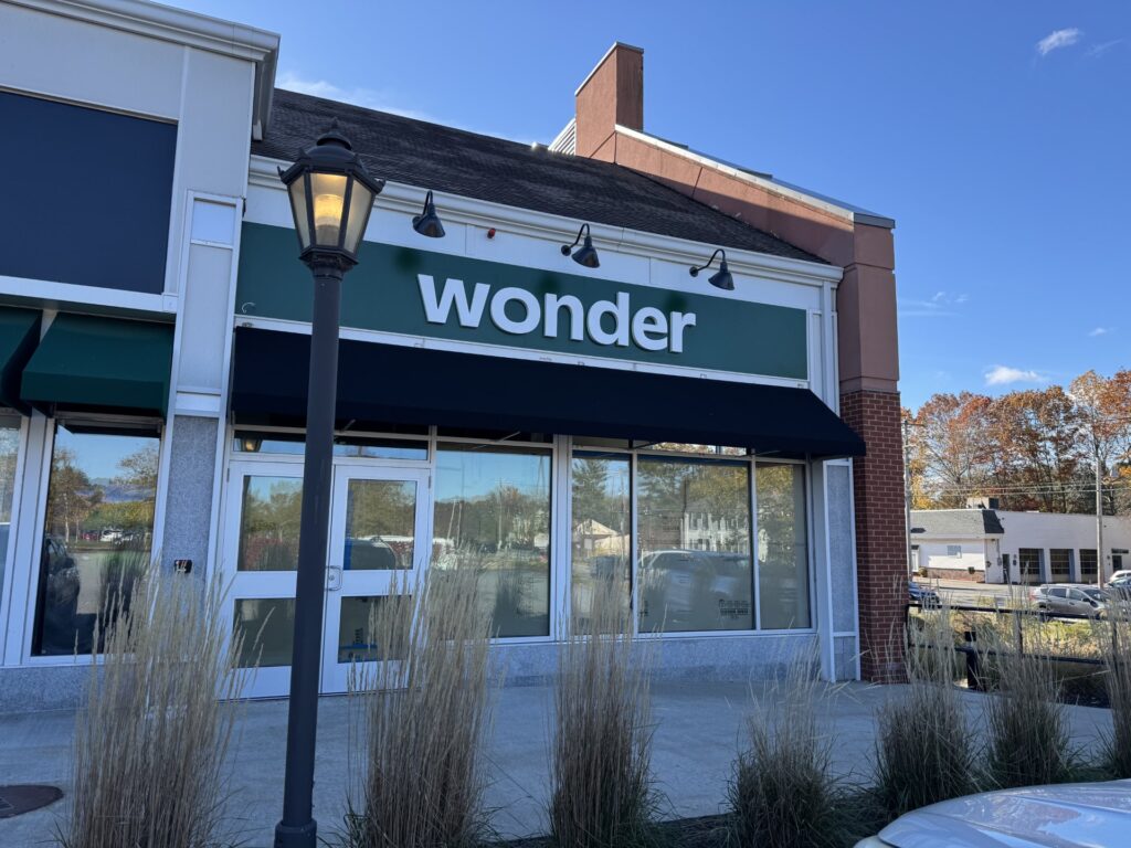 A storefront with a green and white sign that says "wonder."