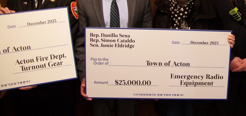 Two large checks are held by anonymous hands.