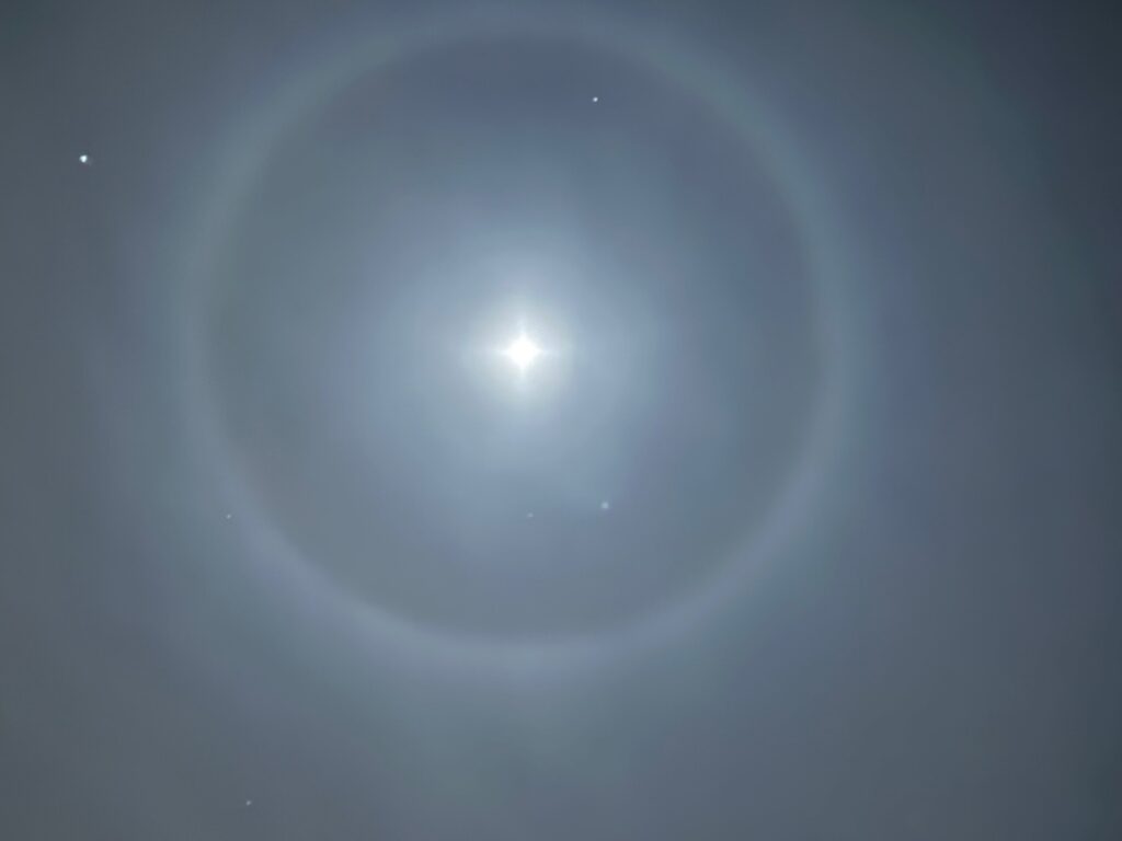 A depth gauge in a stream. There is a bit of ice on the stream and the background is snowy.