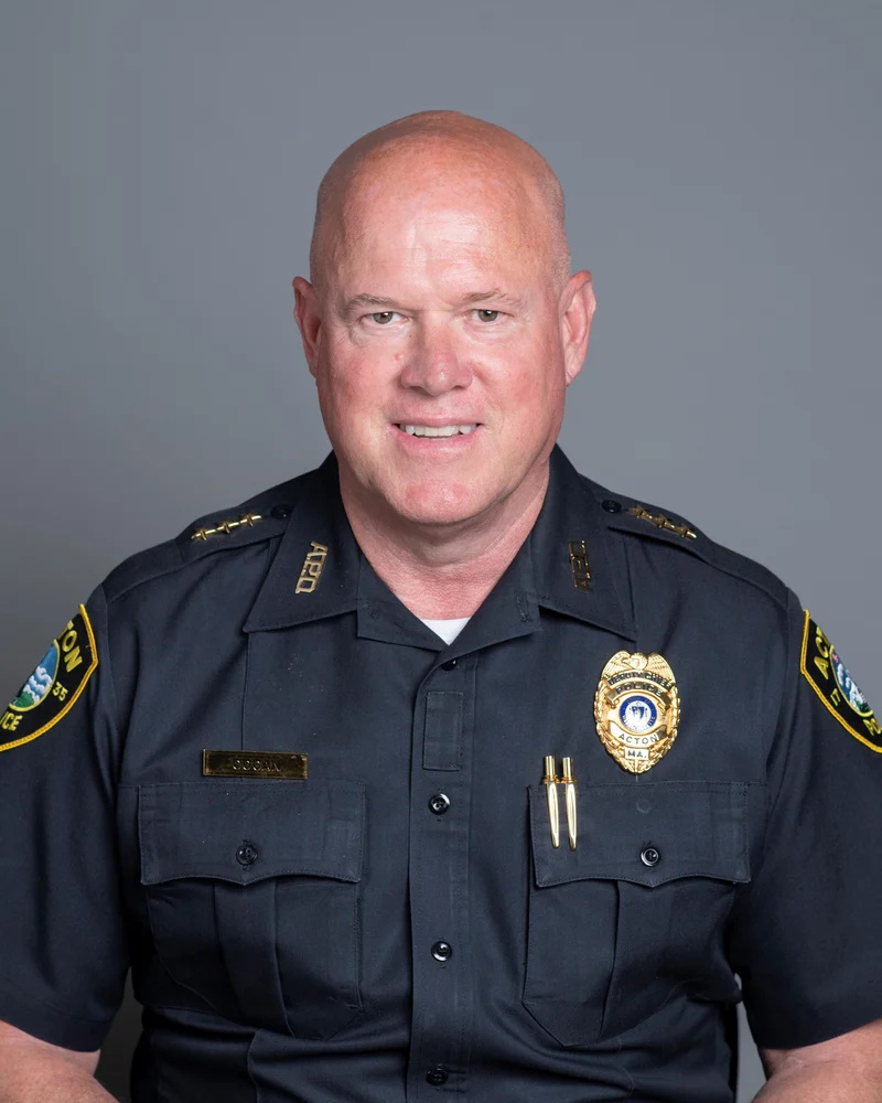 A bald smiling man wearing a police uniform.