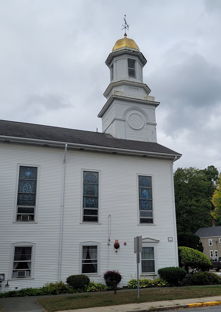 A white church with a gold-leaf covered round steeple.