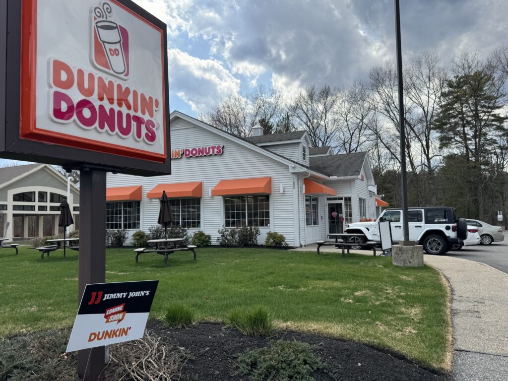 A yardsign in front of the Dunkin' Donuts sign that says "Jimmy John's, coming soon.