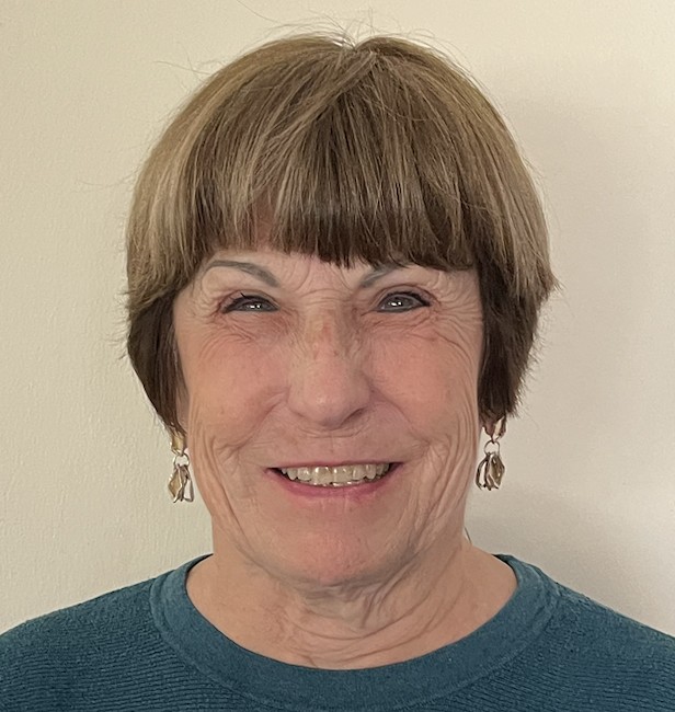 A smiling woman with short brown hair and bangs.