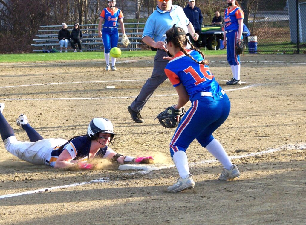 An AB softball player slides into home on her chest while a ball comes in for the catcher (but alas, too late).