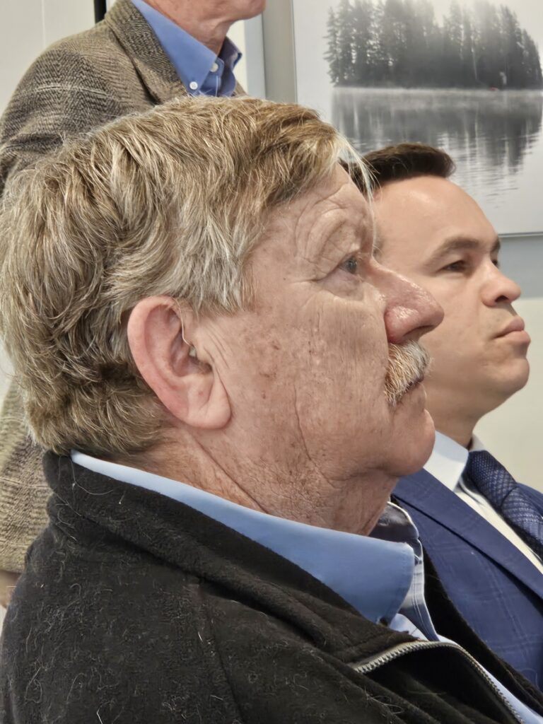 A head shot of two men, one older, one younger, looking at something in the distance.