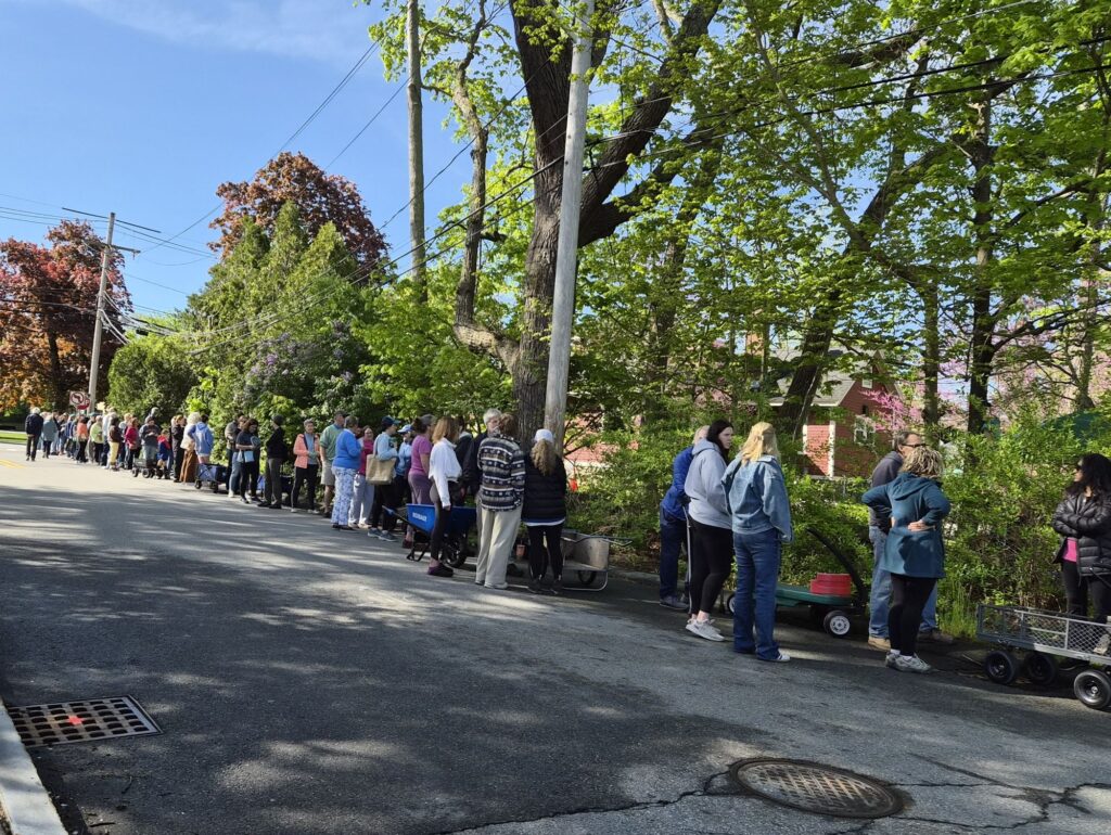 A line of people, some with wagons, stretches all the way down to street from the Red House entrance to Main Street (and around the block).