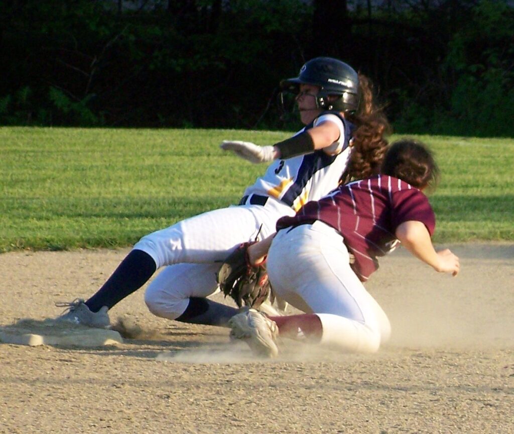 An AB player is almost at the base when a CC player tags her out.