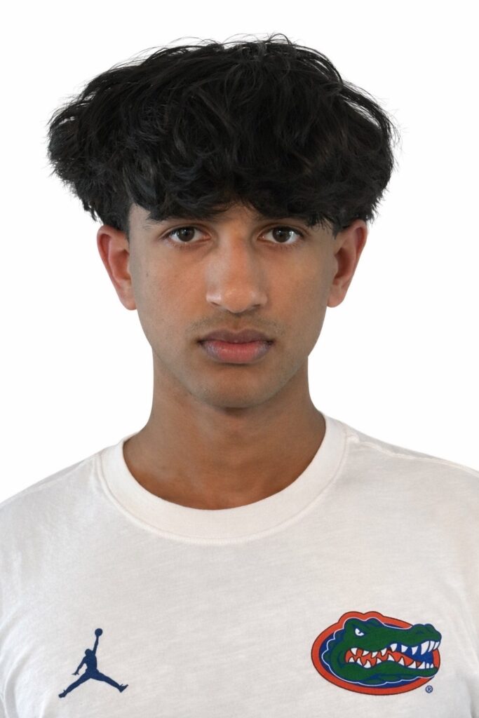 A young man with fluffy hair stares into a camera.