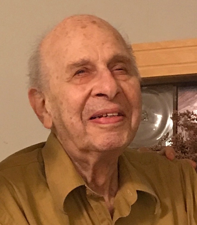 A very old man smiles slyly.