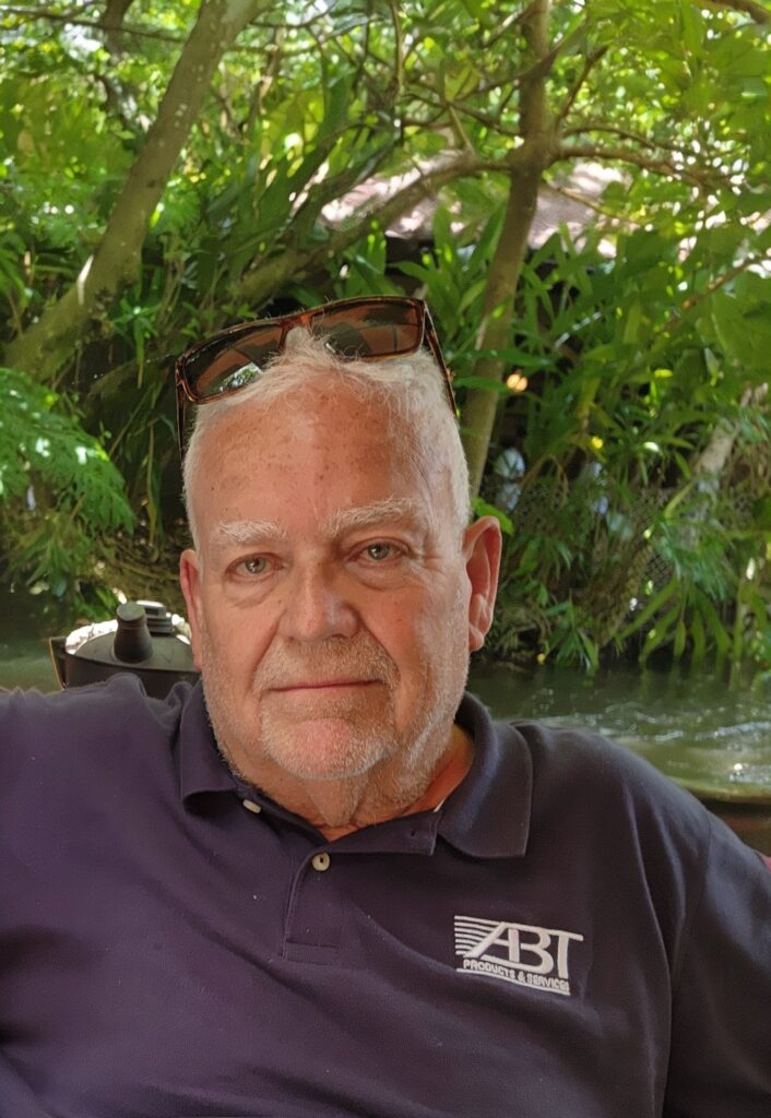 A man with sunglasses perched atop his head looks at the camera.