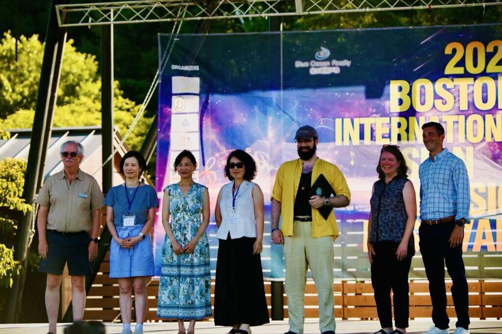 People standing on an outdoor stage.
