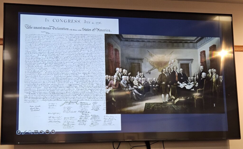 A painting by John Trumbull of the original signing of hte Decaration of Independence overlapping a copy of the original document of the Declaration of Independence.
